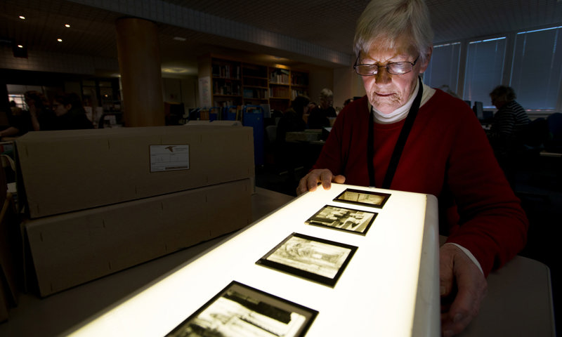 A person looking at archives on a light box 