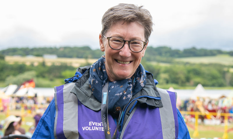 A woman wearing a purple high vis jacket with 'Events volunteer' text on it