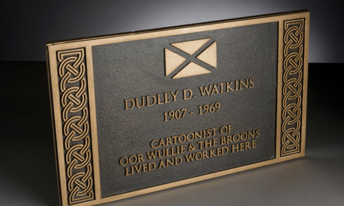 A commemorative plaque dedicated to Dudley D Watkins, creator of The Broons and Oor Wullie cartoons.