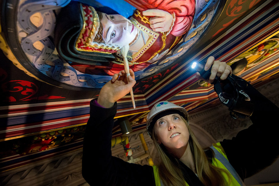 A woman in a hard hat and high vis inspecting a Stirling head on a ceiling at Stirling Castle